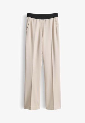 Pantalon beige à jambe droite avec ceinture élastique noire et poches latérales, présenté sur fond blanc.