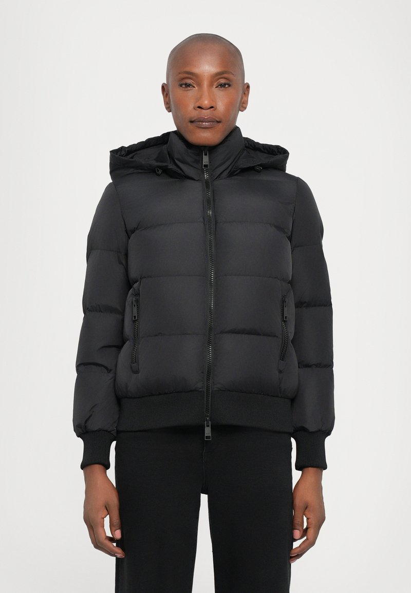 Veste doudoune noire avec capuche, dotée d'une fermeture éclair à l'avant, de poignets et d'un ourlet côtelés, ainsi que de poches latérales zippées. Texture lisse et rembourrée.