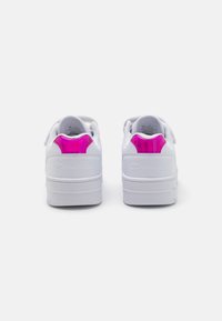 Baskets blanches avec un dessus en cuir lisse, présentant un accent rose brillant au niveau du talon et un logo en relief sur le côté. Semelle en caoutchouc.