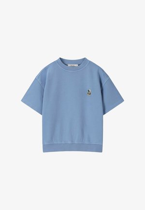 Lichtblauw T-shirt met korte mouwen en een geribde ronde hals en zoom, met een klein rechthoekig patch met een palmboom en zon ontwerp op de borst.