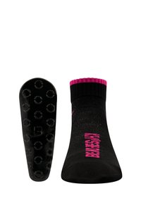 Schwarze Socke mit strukturiertem Sohlenbereich und kreisförmigen Grip-Punkten. Gerippter rosa oberen Rand und rosa Schriftzug an der Seite.