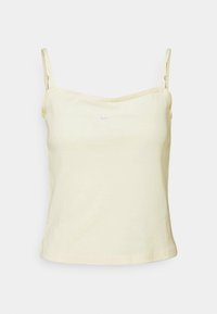 Ljust gult bomullstopp med tunna spagettiband. Har en liten vit Nike-logotyp fram. Mjuk textur och figurnära passform.