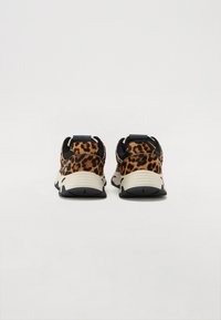 Snesere med leopardmønster og teksturert overdel, svarte detaljer og en dempet såle. Designet har en trekkflik ved hælen.