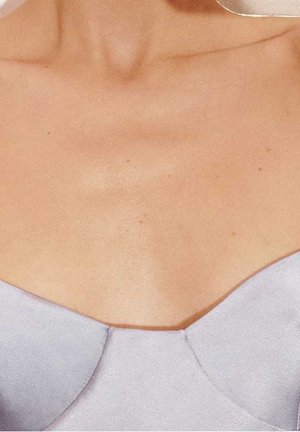 Lavendel satin top med en sweetheart-udskæring, tekstureret stof og glat finish. Har diskrete syninger langs kanterne.