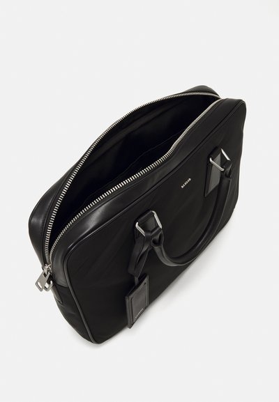 Sort læder aktentaske med lynlåslukning, dobbelt top håndtag og et aftageligt navneskilt. Glat tekstur, rektangulær form, minimale hardware detaljer.