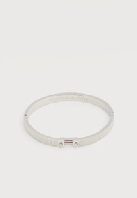 Ασημένιο μεταλλικό βραχιόλι με ραβδώσεις, δύο μικρά κρύσταλλα και το λογότυπο Tommy Hilfiger χαραγμένο στο εσωτερικό.