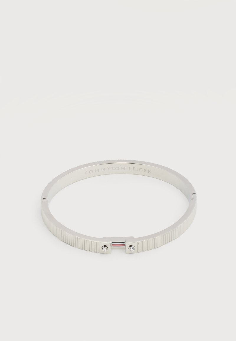 Ασημένιο μεταλλικό βραχιόλι με ραβδώσεις, δύο μικρά κρύσταλλα και το λογότυπο Tommy Hilfiger χαραγμένο στο εσωτερικό.