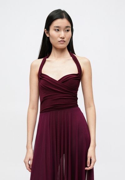 Rochie bordo cu bretele halter, cu un corsaj drapat și înveliș și o fustă vaporosă, transparentă. Textură fină, cu straturi de material pentru un plus de dimensiune.