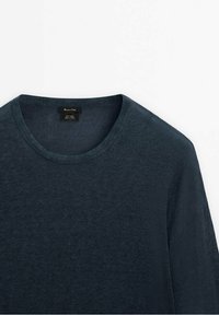 Pull bleu foncé à col rond en tissu tricoté fin, présenté à plat sur fond blanc.
