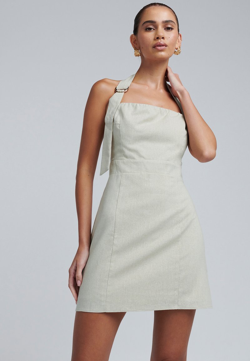 Vestito verde chiaro con scollatura quadrata, spalline a fascia e dettaglio a nodo sul retro. Tessuto liscio e silhouette aderente.