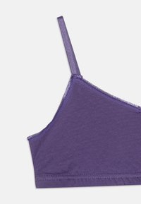 Lila Bralette aus weichem Material mit verstellbaren Trägern und einem strukturierten Saum entlang des Ausschnitts und der Kanten, mit einer glatten Oberfläche.