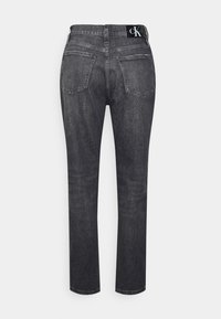 Mustat farkut suoran lahkeen leikkauksella, joissa on vyötärönauhan logo ja kaksi takataskua. Materiaalissa on hienovarainen tekstuuri ja pesuvedoksia.