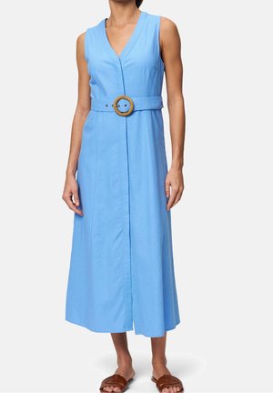 Robe midi bleu clair sans manches avec un col en V et une large ceinture avec une boucle ronde en bois, associée à des sandales plates marron.