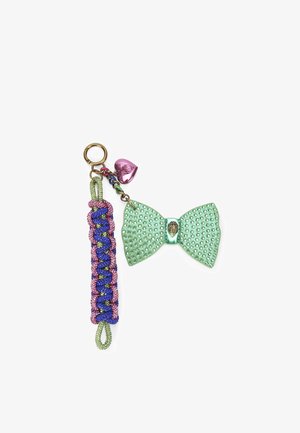 Porte-clés coloré avec un nœud orné de strass verts, accompagné d'un cordon tressé en rose et bleu, surmonté d'un charm en forme de cœur rose.
