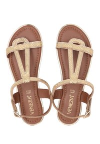 Beige Sandalen mit strukturierten, gewebten Riemen und einer glatten, dunkelbraunen Sohle. Verfügt über metallische Akzente entlang der Kanten und ein offenes Zehendesign.