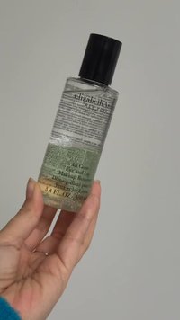 Klares Glasfläschchen mit Elizabeth Arden Make-up-Entferner, 100 ml, mit schwarzem Verschluss. Die Etiketten enthalten den Produktnamen und Anweisungen in mehreren Sprachen.
