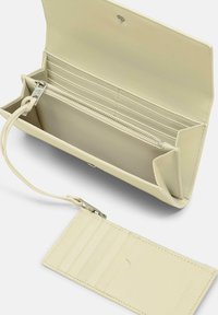 Skórzany portfel w kolorze kremowym z zamykaną na zamek częścią, wieloma przegródkami na karty oraz odpinanym paskiem na nadgarstek. Gładka tekstura i minimalistyczny design.