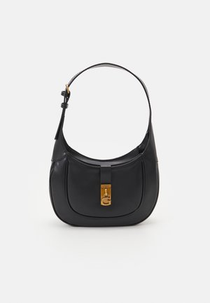 Sac à main en cuir noir avec un design courbé, une quincaillerie dorée et un fermoir proéminent arborant un logo "G". Bandoulière réglable.