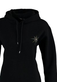 Czarna bluza z kapturem ze sznurkami oraz małym, kolorowym wzorem gwiazdy wybuchającej na lewej części klatki piersiowej.