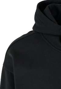 Sweat à capuche noir avec un col haut replié et une couture d'épaule visible, vu de l'avant côté droit.
