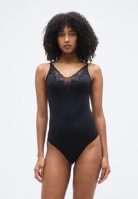 Μαύρο κορμάκι με δαντελένια διακόσμηση στη λαιμόκοψη και ρυθμιζόμενους ιμάντες. Ομαλό, ελαστικό ύφασμα με εφαρμοστή σιλουέτα.