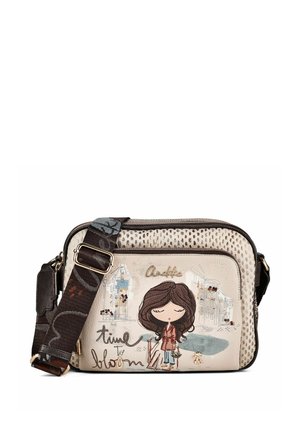 Beige Umhängetasche mit verstellbarem dunkelblumigem Riemen, mit Cartoon-Mädchen-Illustration und Text "time to bloom" auf der Vordertasche.