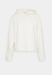 Sudadera recortada en un color crema claro, hecha de tejido suave. Presenta una capucha con cordón, mangas raglán y un diseño sencillo y limpio.