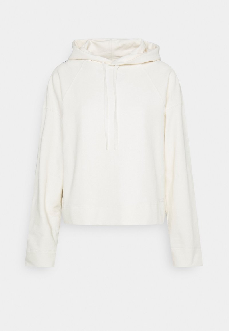 Sudadera recortada en un color crema claro, hecha de tejido suave. Presenta una capucha con cordón, mangas raglán y un diseño sencillo y limpio.