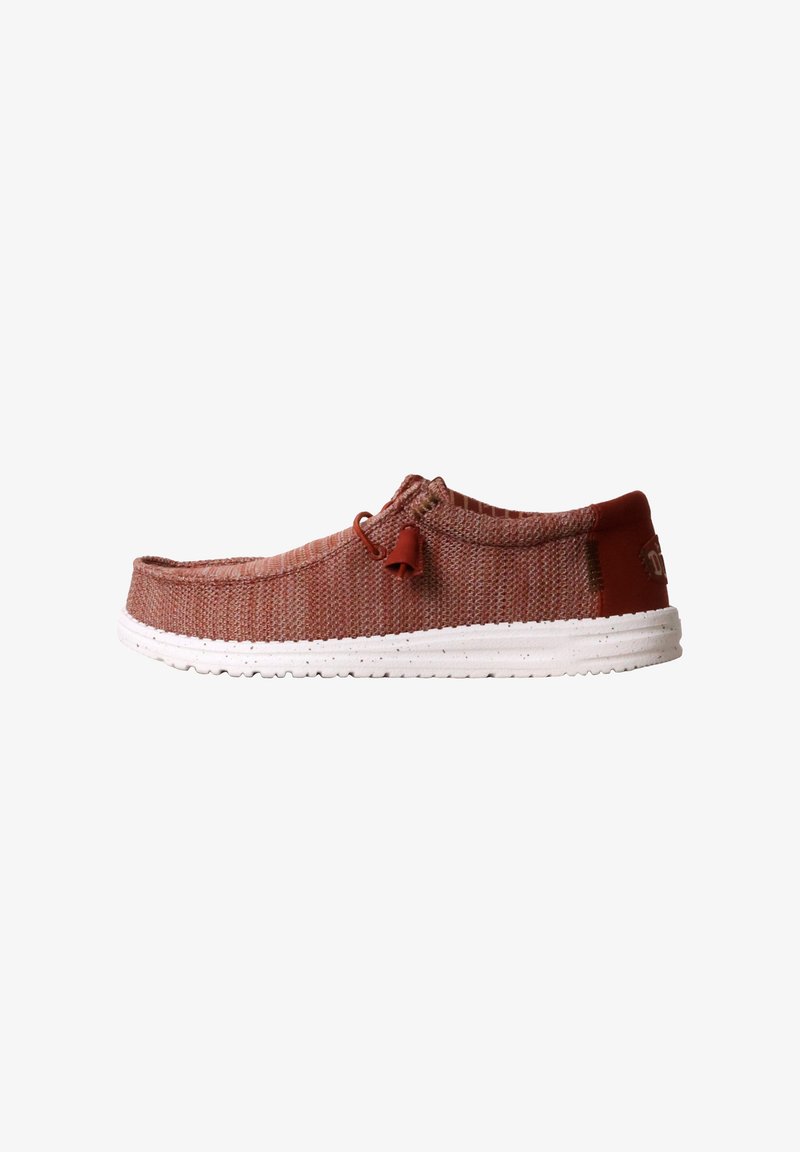 Chaussure décontractée rouge tissée sans lacets avec semelle blanche mouchetée et détail de lacet élastique, vue de côté sur fond blanc.