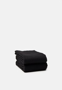 Serviettes noires pliées, en tissu doux, avec une surface texturée et des bords lisses. Forme compacte avec un empilement soigné.