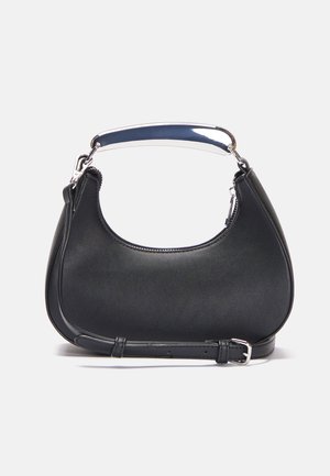 Sac à main noir en forme de croissant avec une poignée courte en argent et une longue sangle réglable avec une boucle, sur un fond blanc.