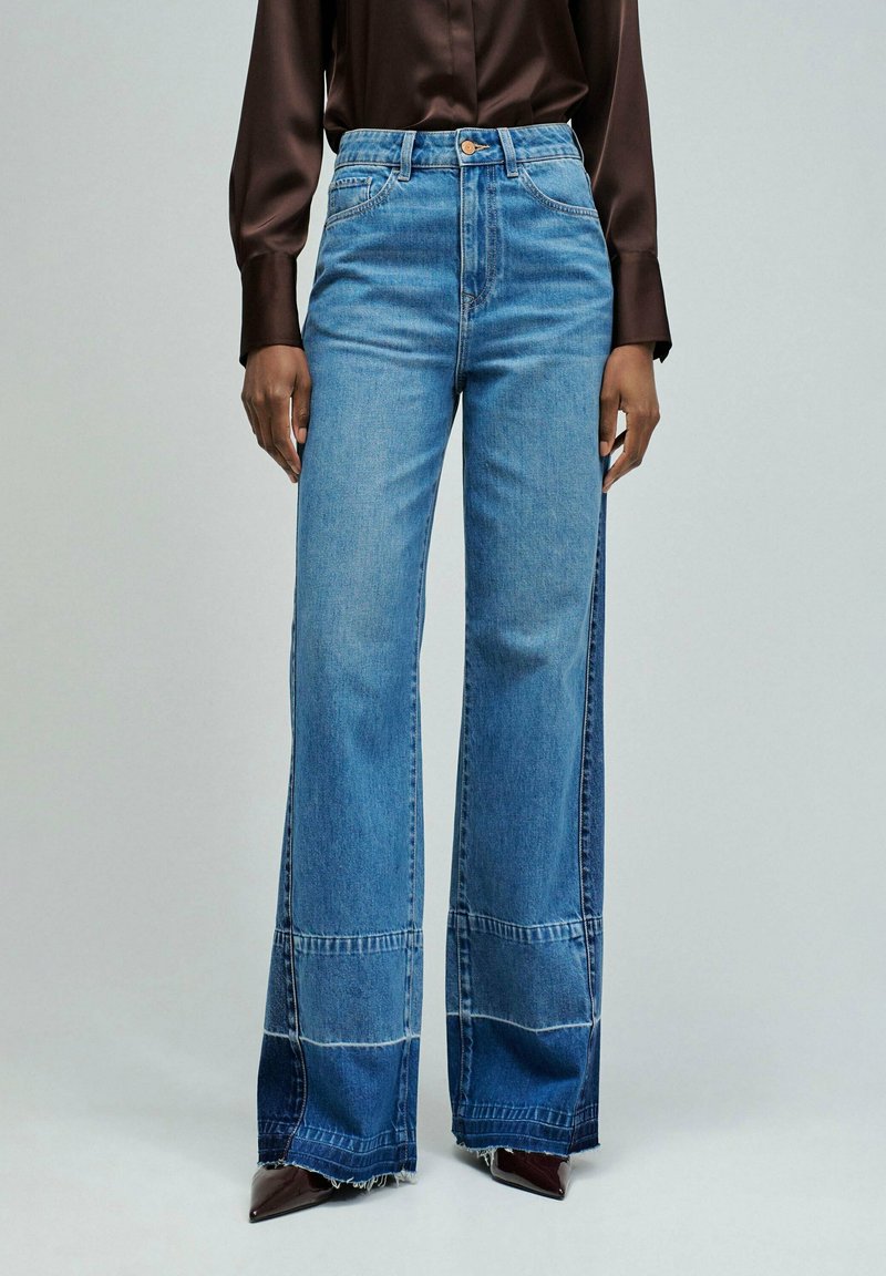 Weit geschnittene Jeans aus verblasstem blauem Denim mit hoher Taille und markanten Einsätzen, versehen mit ausgefranstem Saum und einem Design mit fünf Taschen.