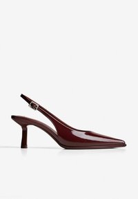 Pantof sau slingback din piele lacuită burgundy, cu vârf ascuțit, toc mediu și curea ajustabilă, pe fundal alb.