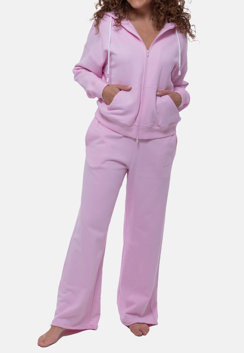 Roze fleece hoodie met voorzakken en verstelbare trekkoorden; bijpassende wijde broek. Glad materiaal, comfortabele pasvorm.