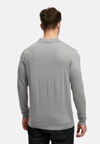Grå långärmad tröja med krage, ribbade ärmslut och nederkant. Mjuk textur och figurnära design, som visar baksidan.