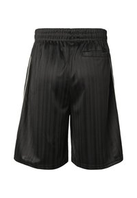 Shorts en satin noir à rayures verticales, taille élastique, poches latérales et une seule poche arrière avec rabat.