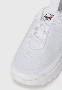 Nike Air Max tenisky, prevažne biely sieťovinový zvršok s textúrovanými vzormi, syntetická špička a šnúrky, s logom na jazyku.
