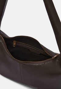 Borsa a spalla in pelle marrone scuro con cerniera dorata, che mostra il compartimento principale aperto e una tasca interna con zip dotata di un tirante in pelle brandizzata.