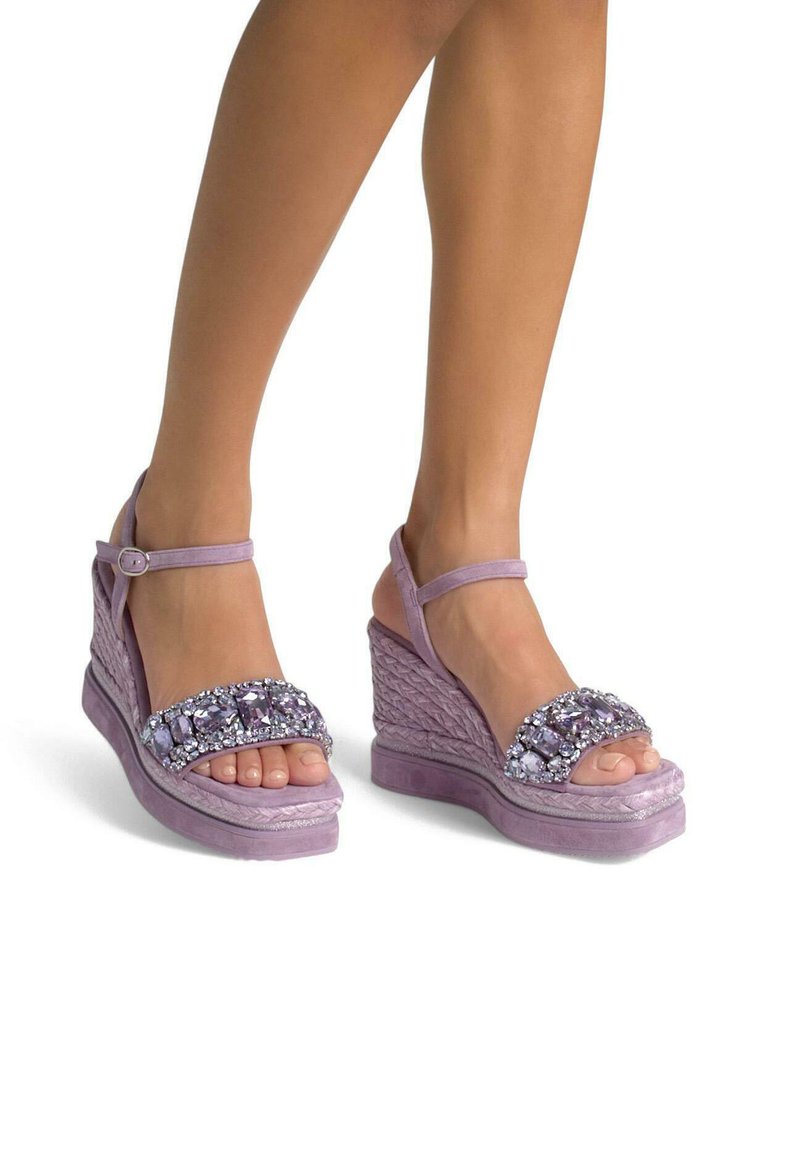 Sandali wedge viola con texture intrecciata, cinturini decorati con grandi pietre decorative e un design di cinturino alla caviglia sicuro.