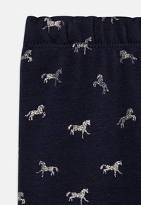Tengerés leggings ezüst glitter ló mintával, rugalmas derékpánttal, puha textúrával és szoros illeszkedéssel.