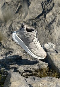 Šedá turistická obuv s horní částí z prodyšné síťoviny, pryžovou podrážkou a strukturovanými detaily. Má tkaničky, zesílené průvleky a detail s logem.