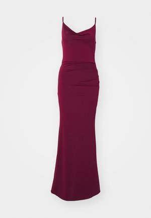 Burgundy maxi dress with a cowl neckline, thin straps, fitted bodice, and draped detailing on the hip for a streamlined silhouette.