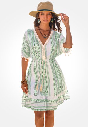 Robe blanche avec motifs de feuilles vertes, encolure en V et accents de pompons. Comprend des manches courtes et une taille élastique pour un ajustement confortable.