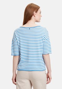 Pasiasty niebiesko-biały top z krótkimi rękawami, szerokim dekoltem i małym guziczkiem z tyłu. Miękka, teksturowana tkanina.