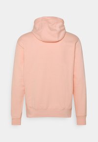 Ljusrosa huvtröja sedd bakifrån med långa ärmar och ribbade muddar och nederkant.