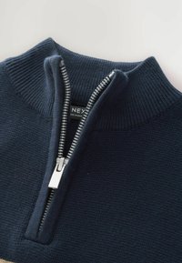 Maglione navy con zip, colletto a costine, cerniera argentata e tessuto testurizzato. Presenta un'etichetta visibile all'interno della zona del colletto.