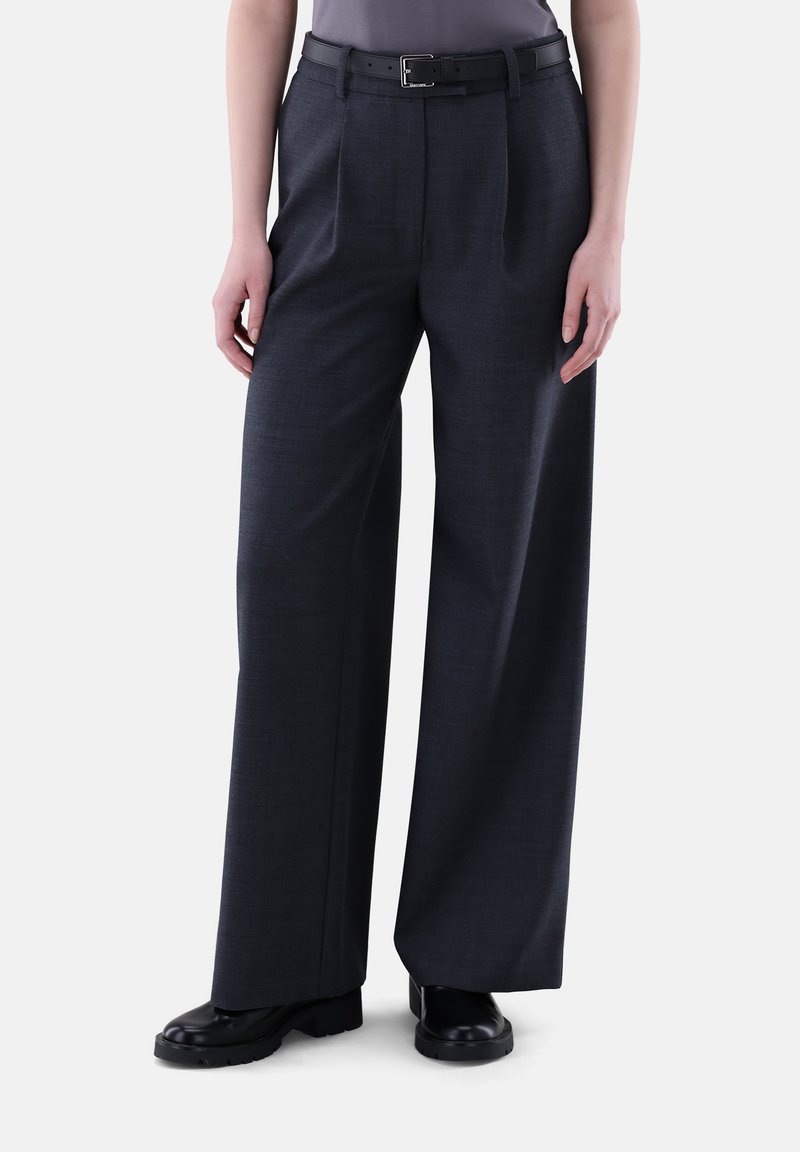 Weite Hosen aus dunkelgrauem Stoff mit feiner Textur. Ausgestattet mit einem schwarzen Gürtel und mit vorderen Falten für zusätzlichen Detailreichtum gestaltet.