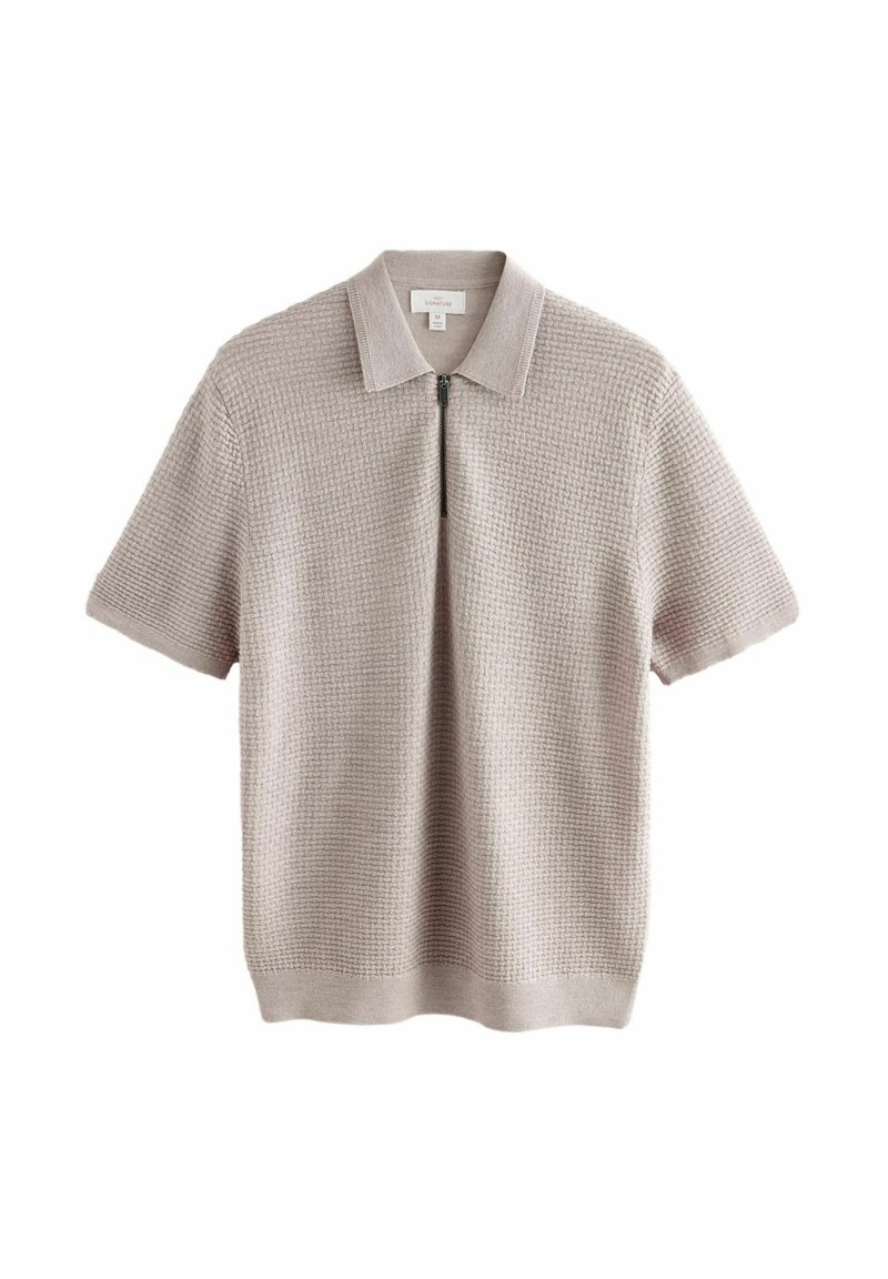 Polo de punto de manga corta en beige claro, con un patrón texturizado, cuello plano y cierre frontal de media cremallera. Material suave.
