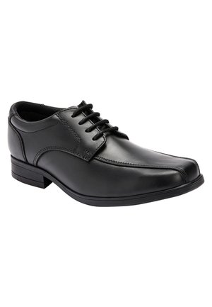 Chaussure de ville noire en cuir pour homme avec lacets à l'avant et petit talon, montrant les détails latéraux et frontaux sur fond blanc.