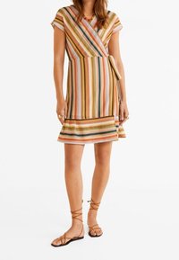Gestreiftes Wickelkleid mit kurzen Ärmeln, in Orange-, Grün- und Gelbtönen. Weiche Textur, ausgestellter Saum und mit einem seitlichen Band verziert.